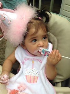 Eating her cake and a lollipop at the same time.